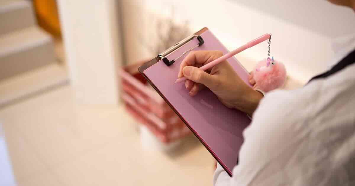 Photo of a lady holding a clipboard and pen